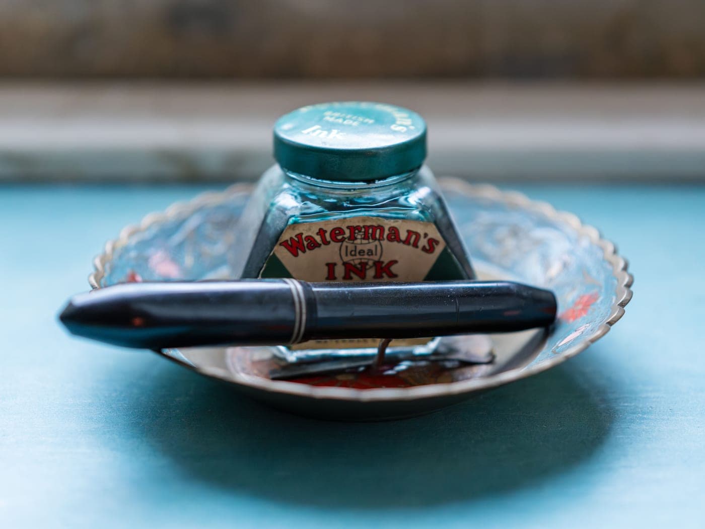 An ink bottle and fountain pen on a desk